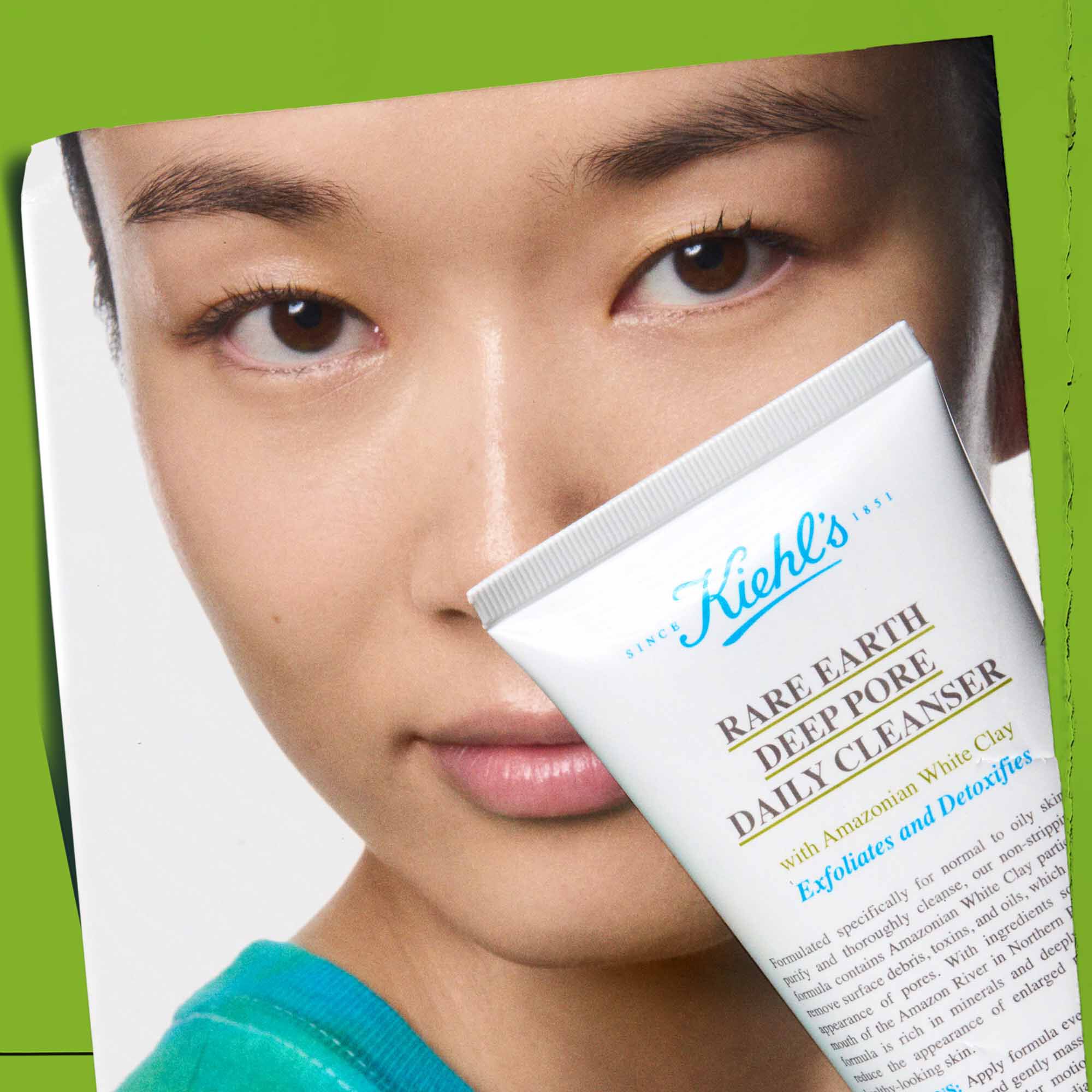 A person holding a tube of Rare Earth Deep Pore Daily Cleanser, showcasing its use.