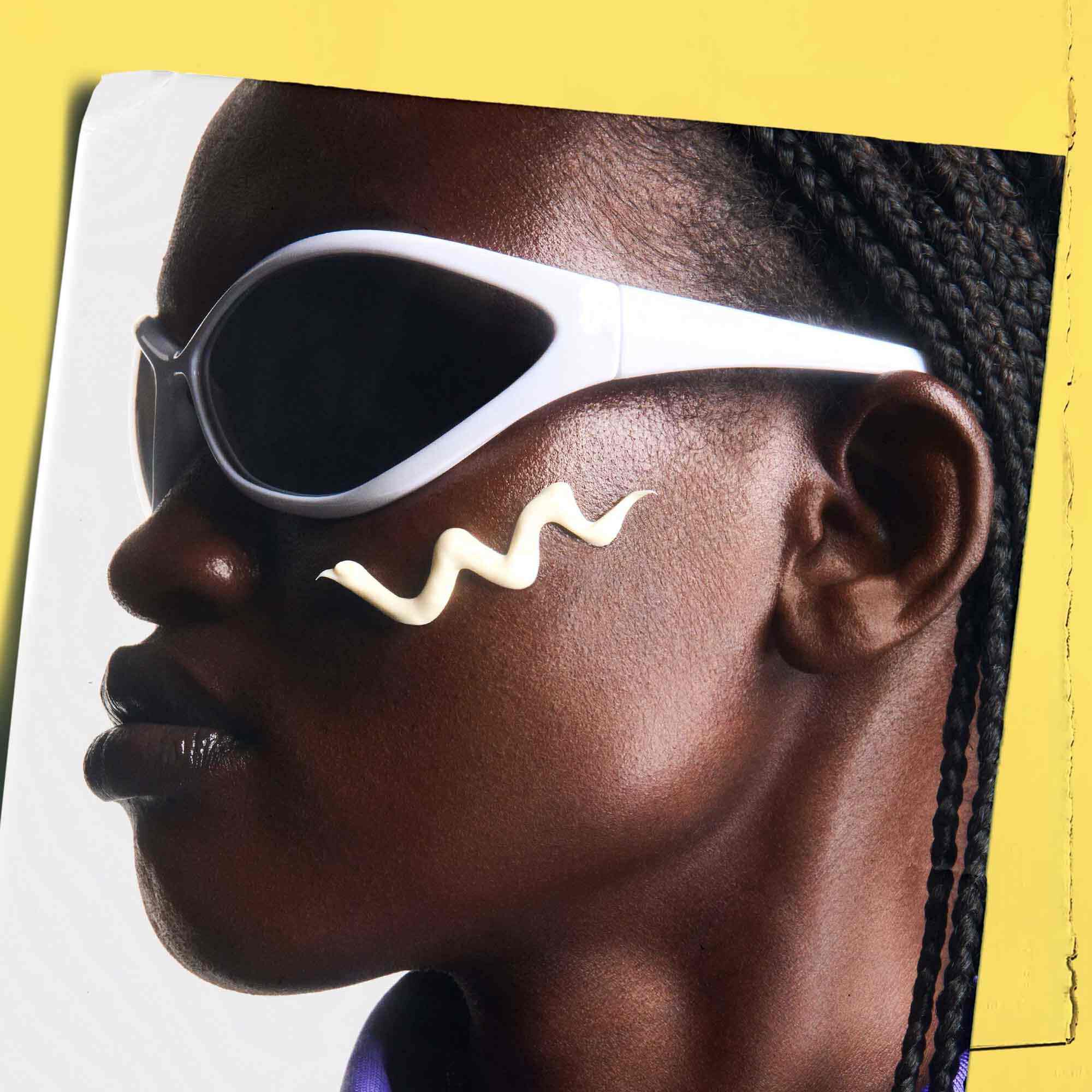 Ultra-Light Daily UV Defense applied to skin, showcasing a person wearing sunglasses.