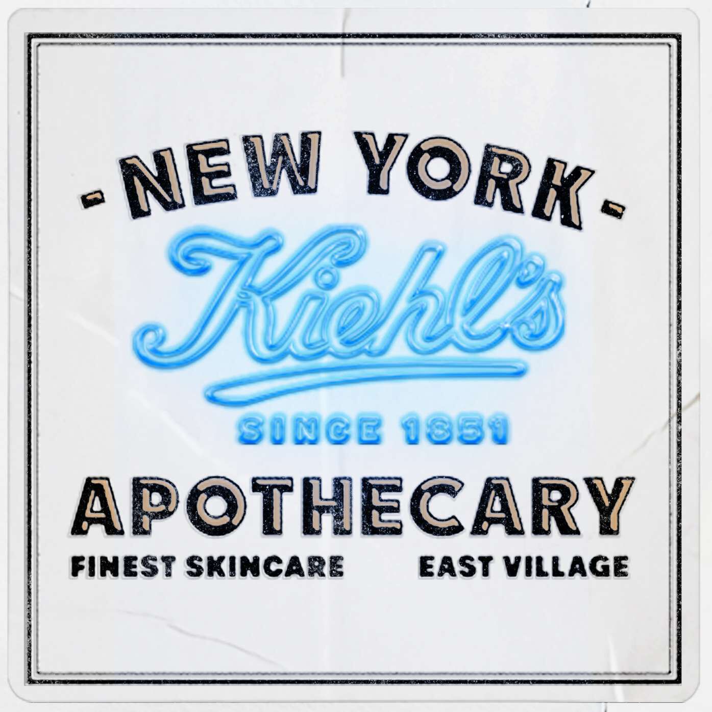 Kiehl’s Since 1851 apothecary label in New York’s East Village. Features the brand logo in blue neon style text on a white vintage background with the words "Finest Skincare."