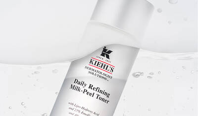 A bottle of Kiehl's Daily Refining Milk-Peel Toner, featuring a clean, minimalist design with a white background and water droplets.
