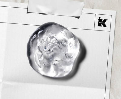 Close-up of a clear, textured skincare gel droplet on a laboratory document, featuring Kiehl’s iconic "K" logo, illustrating the brand's clinical approach to formula development. 