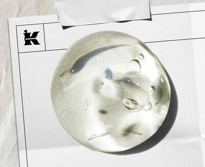 A wooden spoon holds several translucent, cube-shaped jelly candies on a white background.