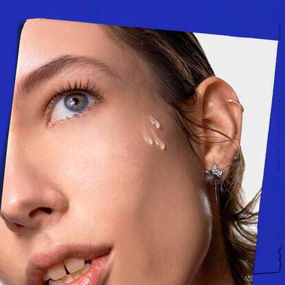 Close-up of a person with wet hair, showcasing clear droplets on their cheek, wearing star-shaped earrings. The background is white and bordered by blue.